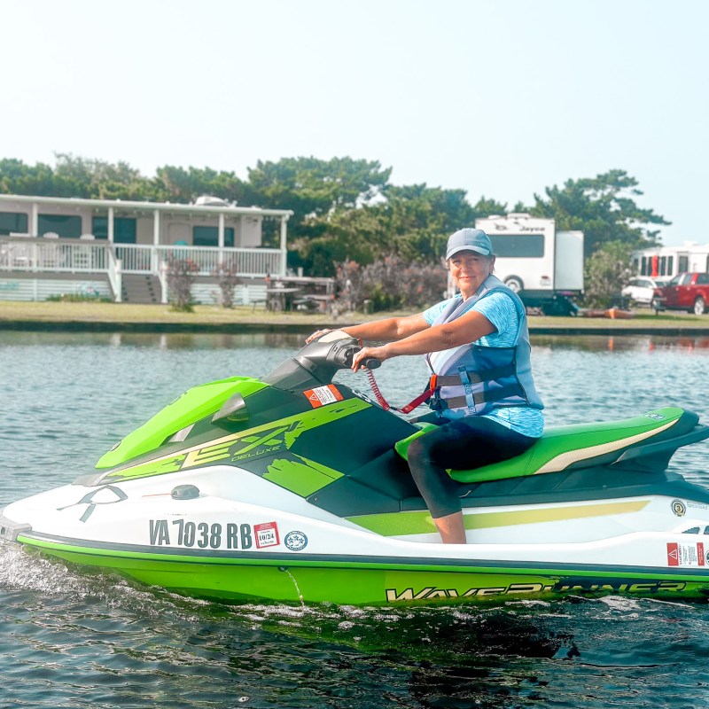 a man riding on the back of a boat in the water