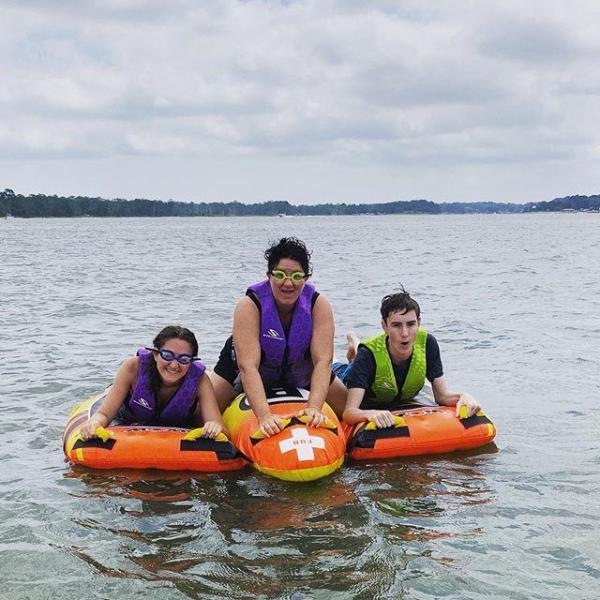 a group of people riding on the back of a boat in the water